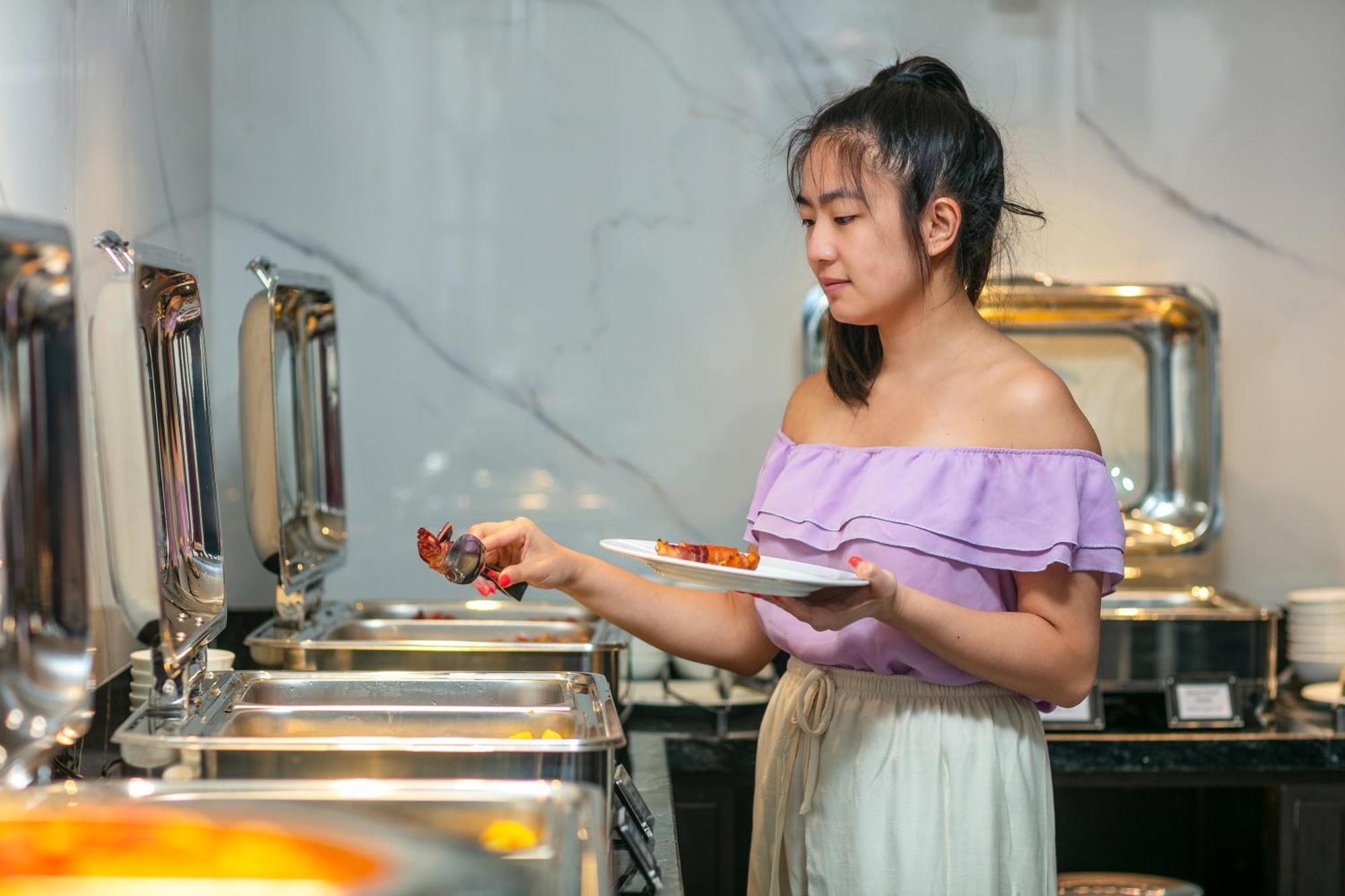 May De Ville Lakeside Hotel Hanoi Eksteriør billede A woman serving herself at a buffet